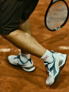 Tennis player's leg with a racket in the action.