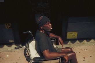 Man in wheelchair smokes a cigarette.