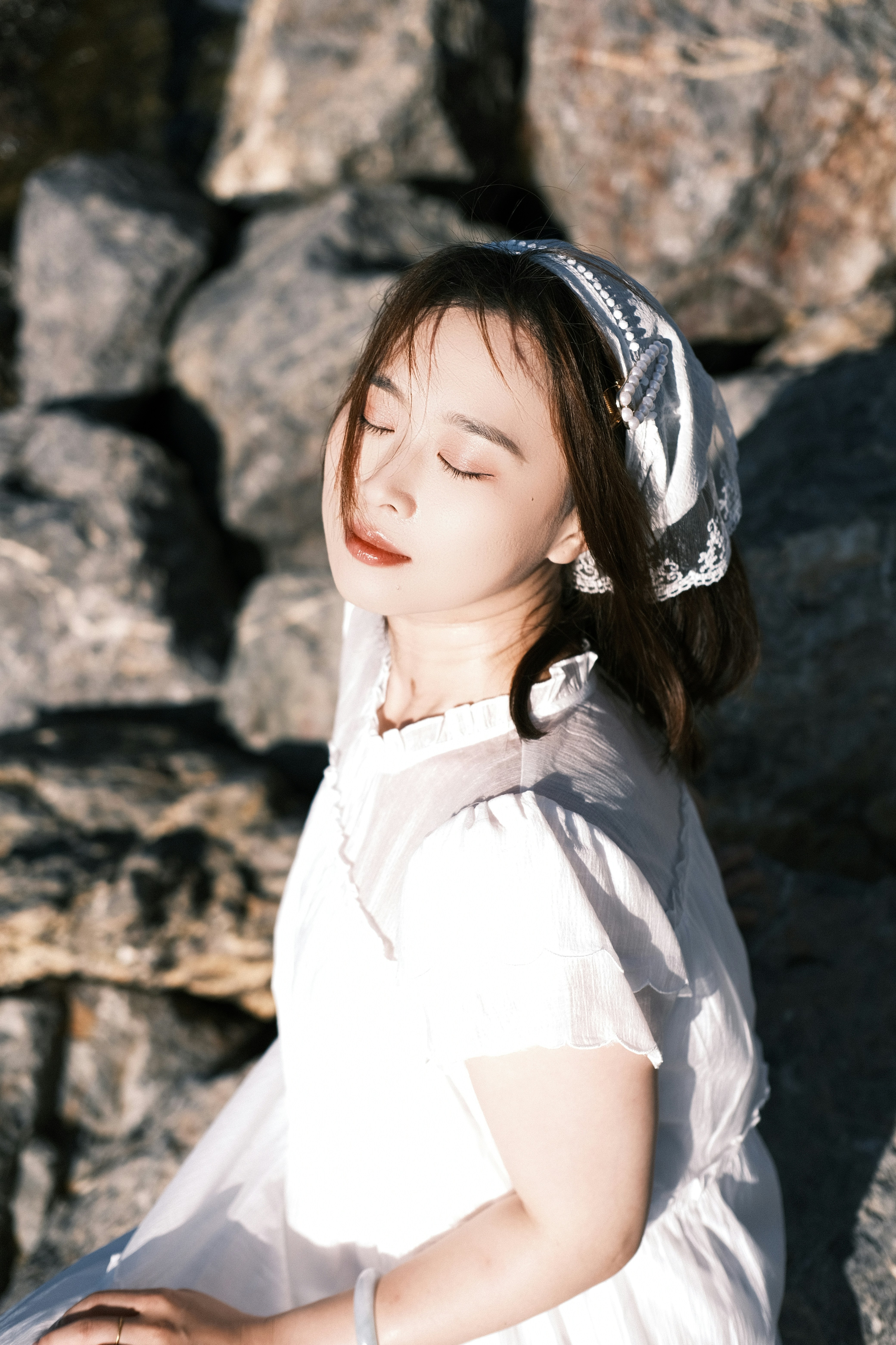 A woman enjoys sunlight with her eyes closed.