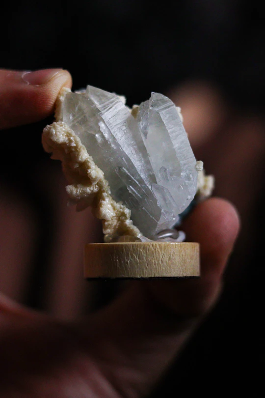 A hand holds a beautiful crystal cluster.