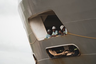 Workers in a ship's window.