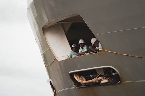 Workers in a ship's window.
