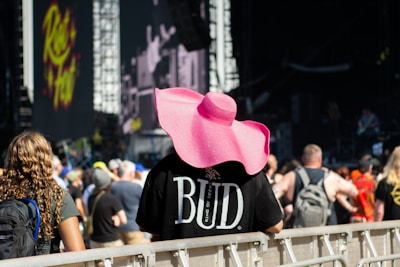 A person in a pink hat at a concert.