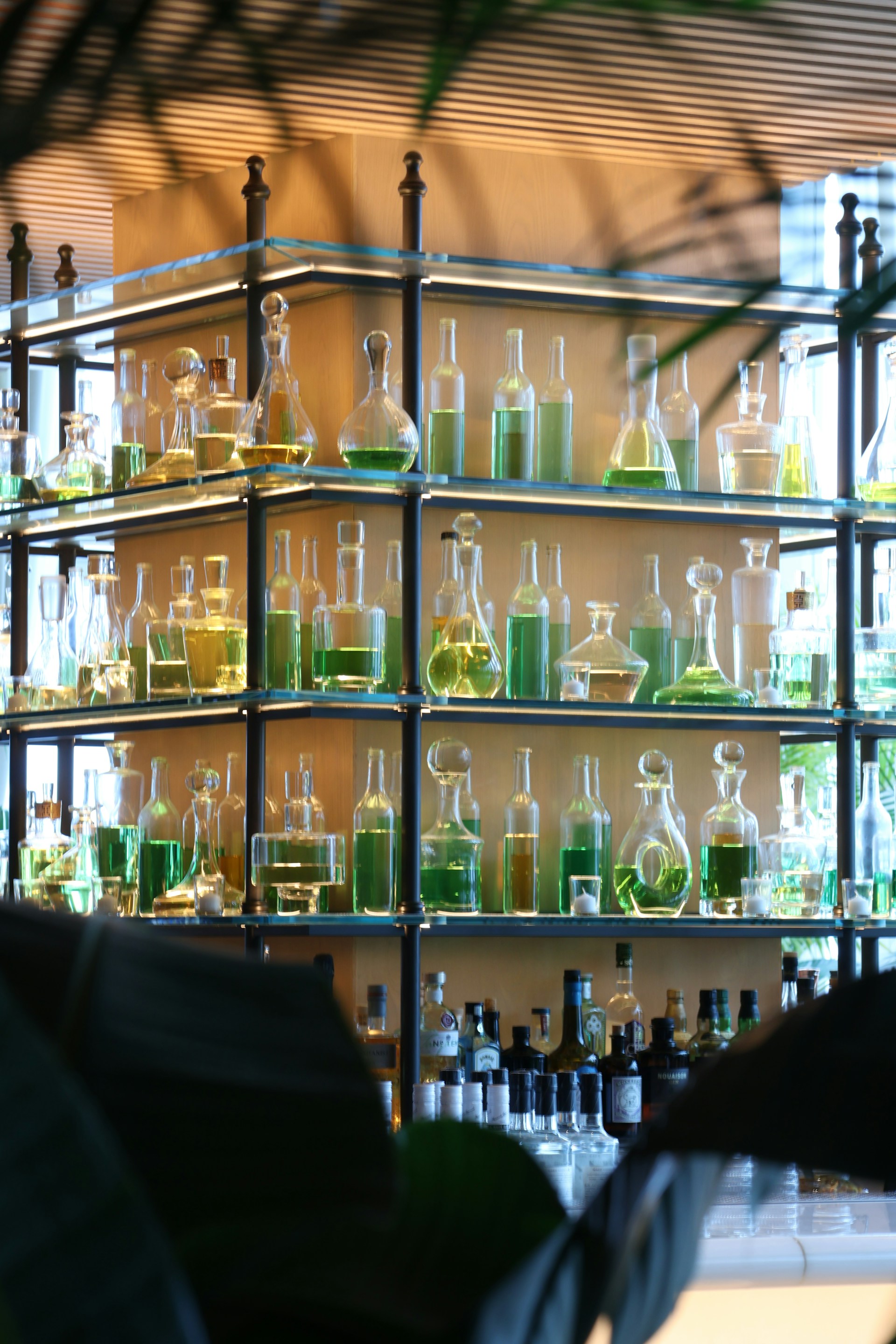 Glass bottles of liquids are displayed on shelves.