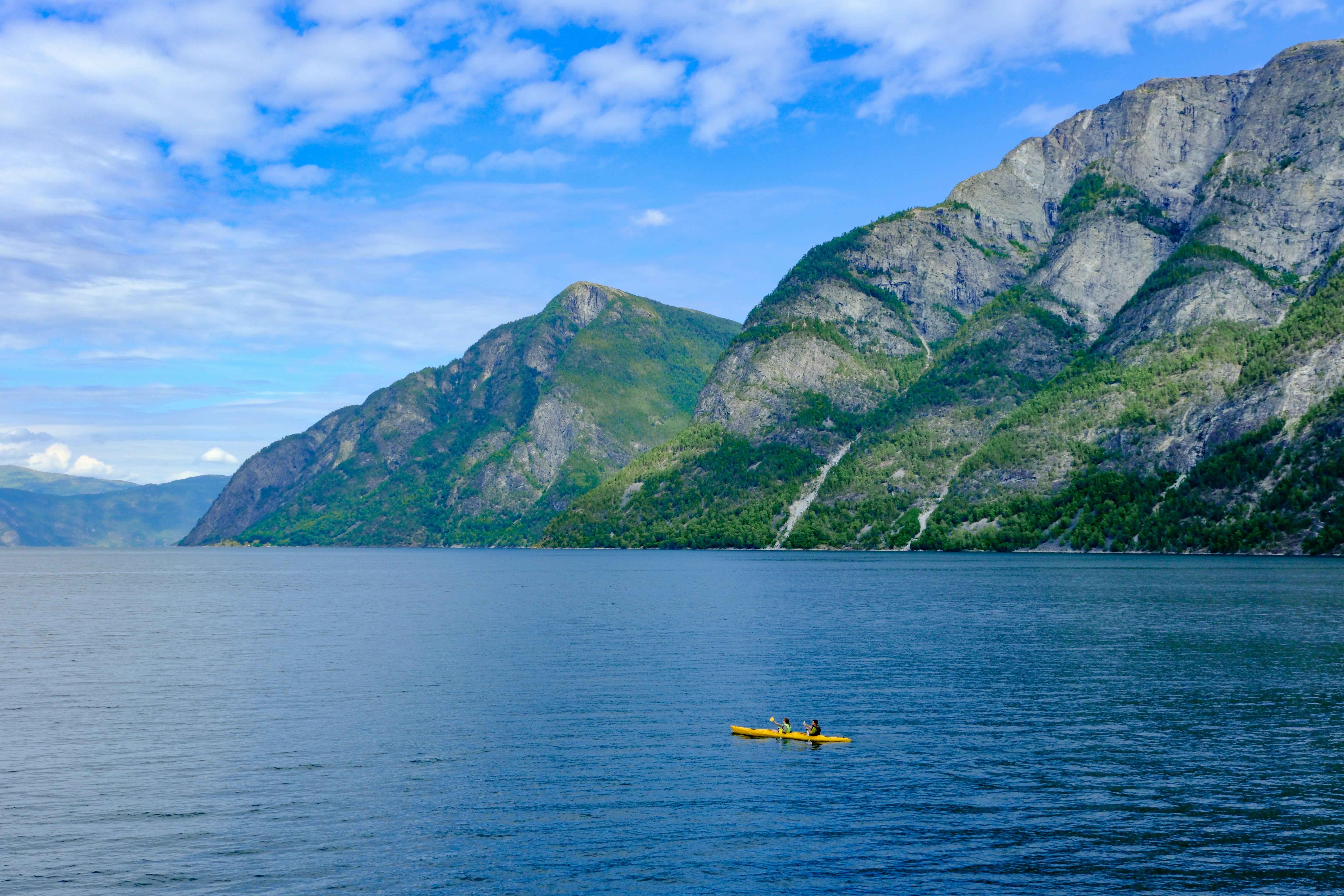 person kayaking through a dramatic fjord - inspirational travel