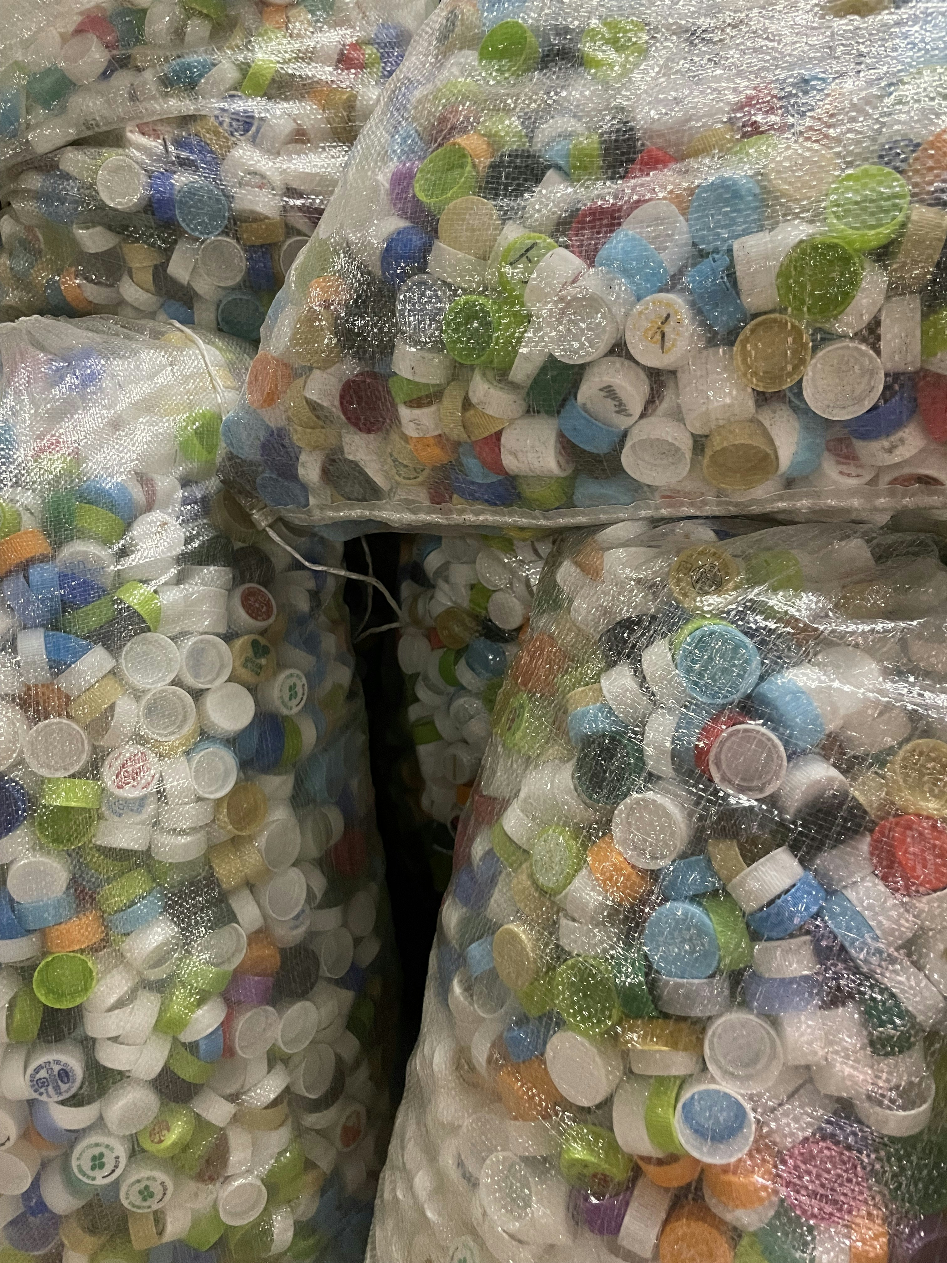 Le borse sono piene di tappi di bottiglia colorati.