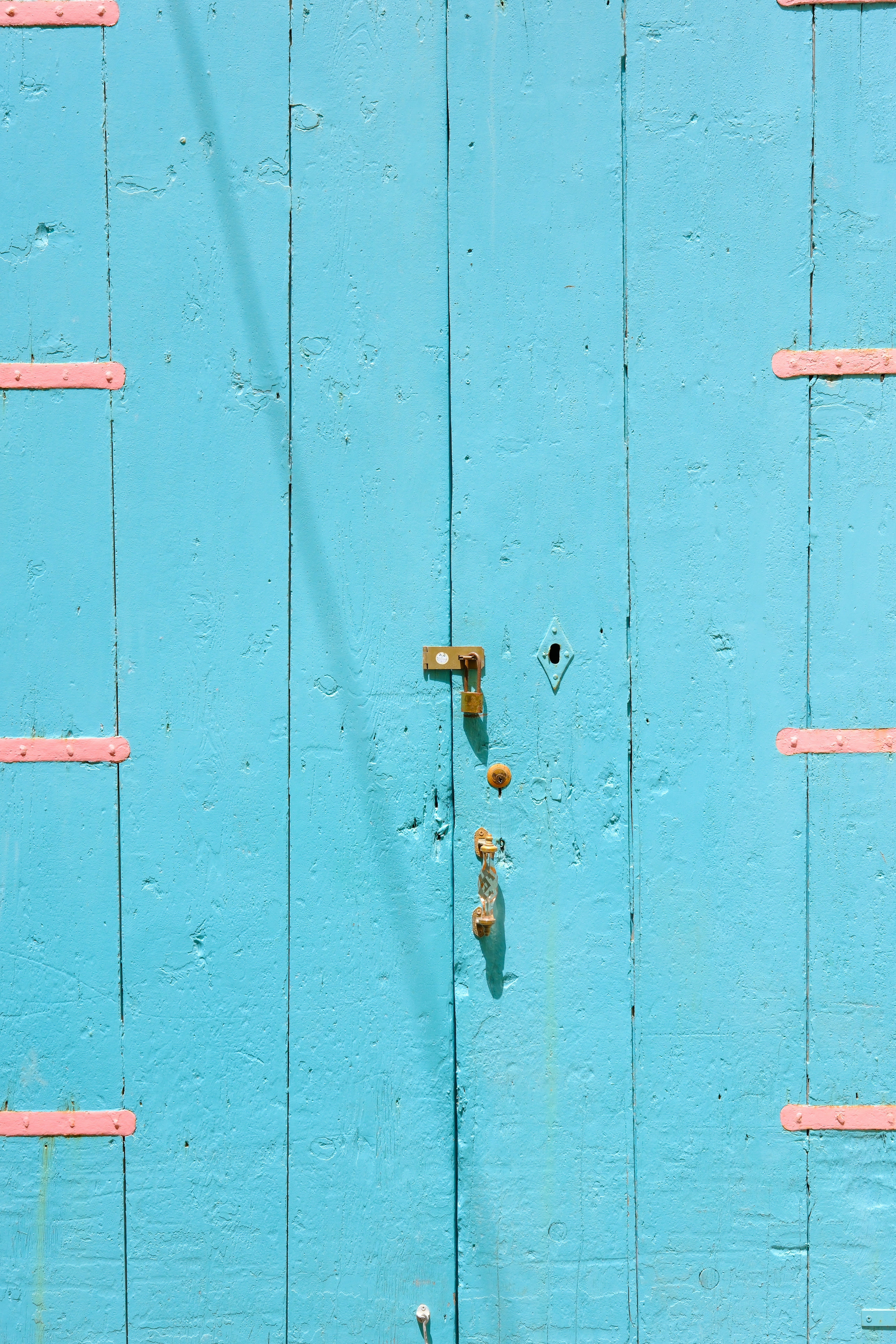 Blue door with pink accents and a keyhole.