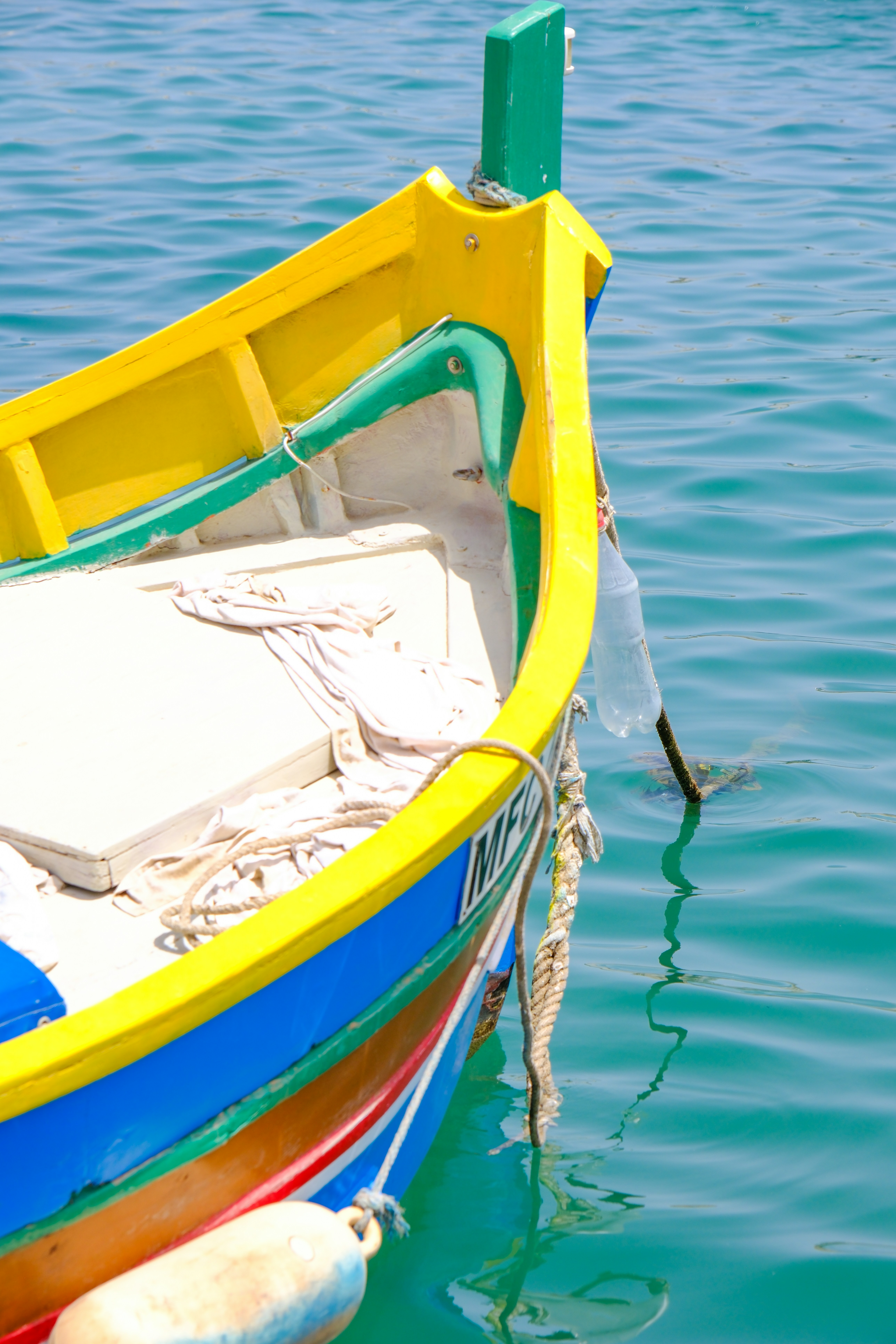 A colorful boat floats in the calm water.