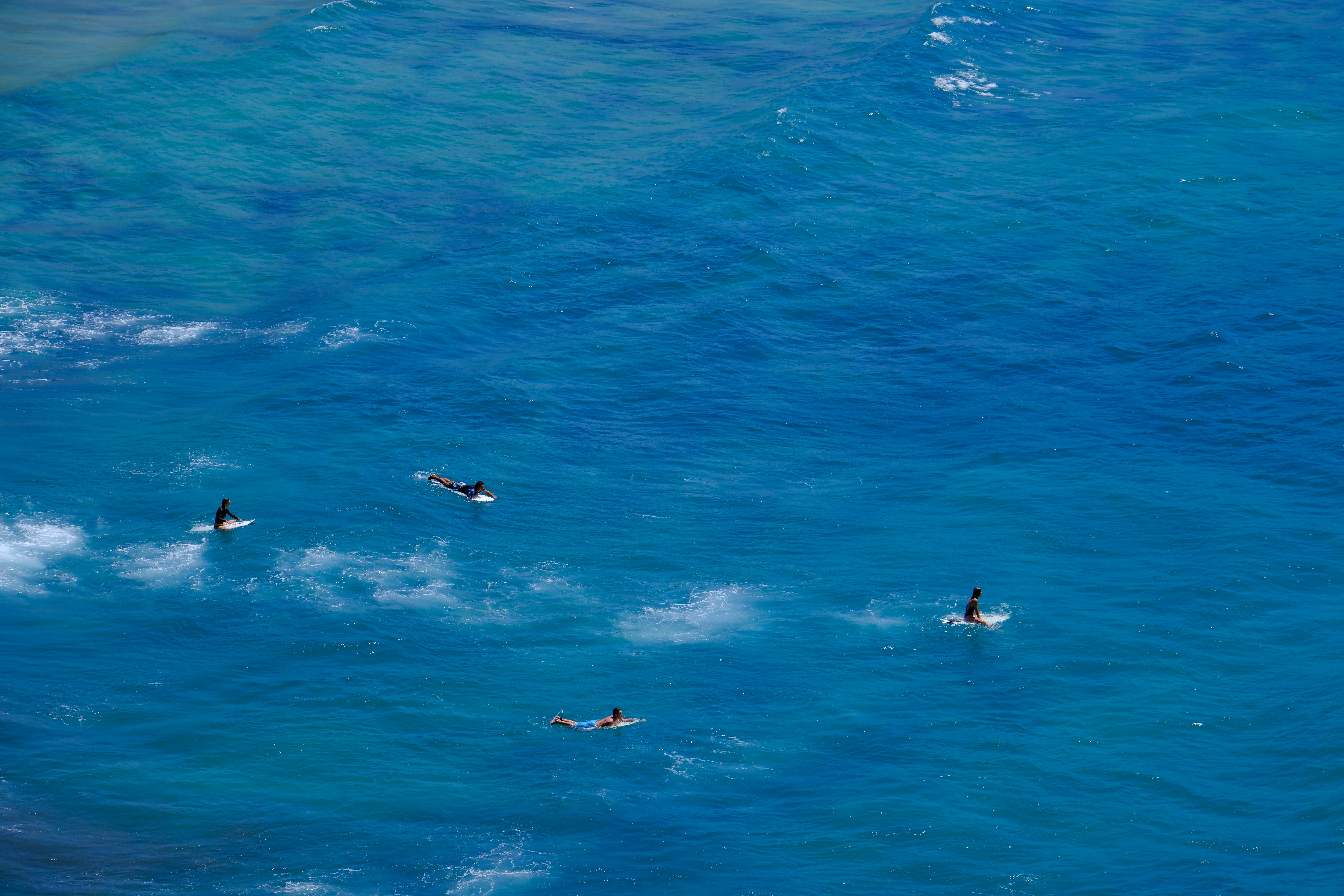 Surfers ride waves in the deep blue ocean.