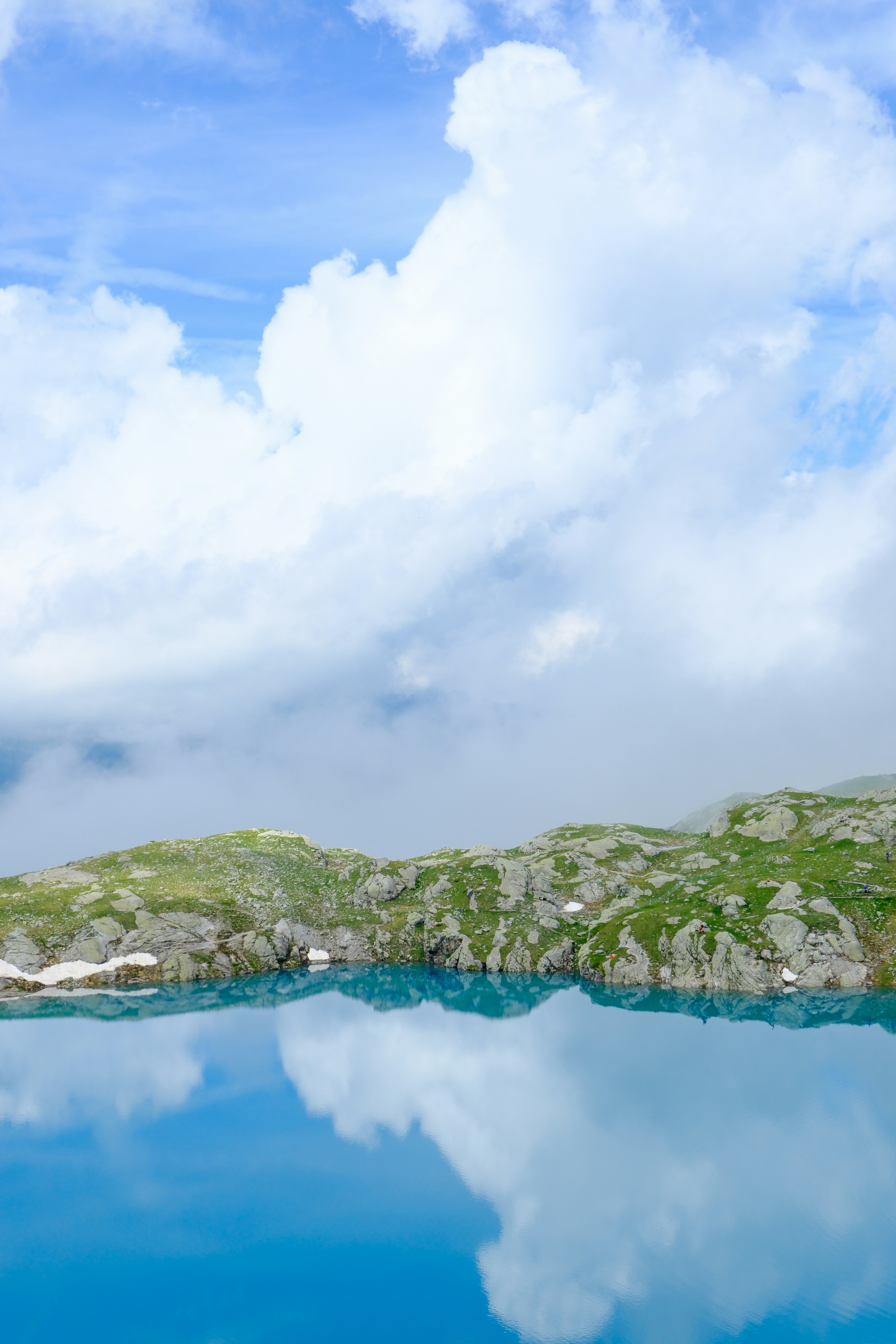 Bright turquoise water reflects a cloudy sky.