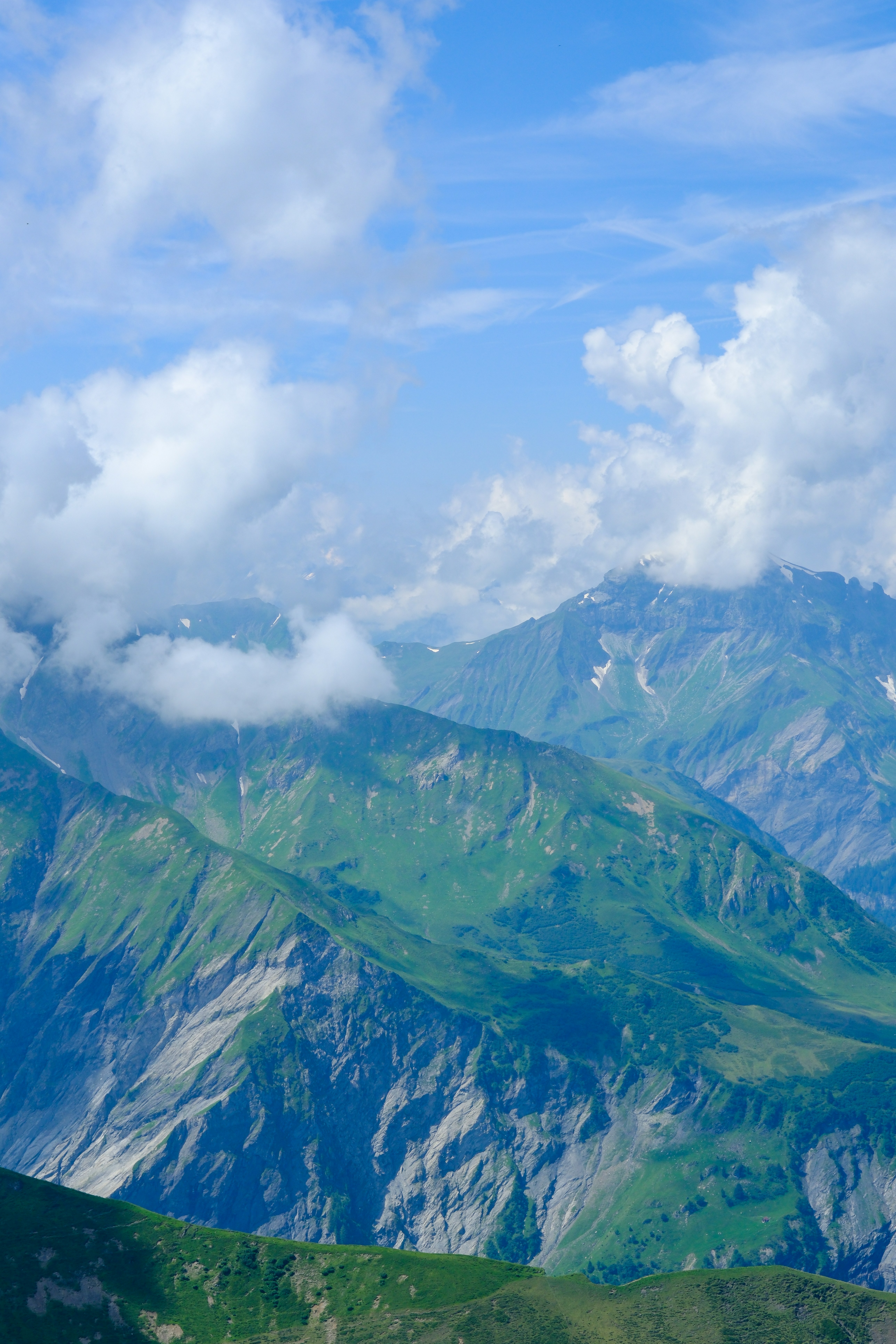 Mountains emerge from the clouds under a blue sky.