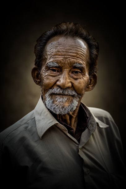Smiling elderly man poses for a portrait.