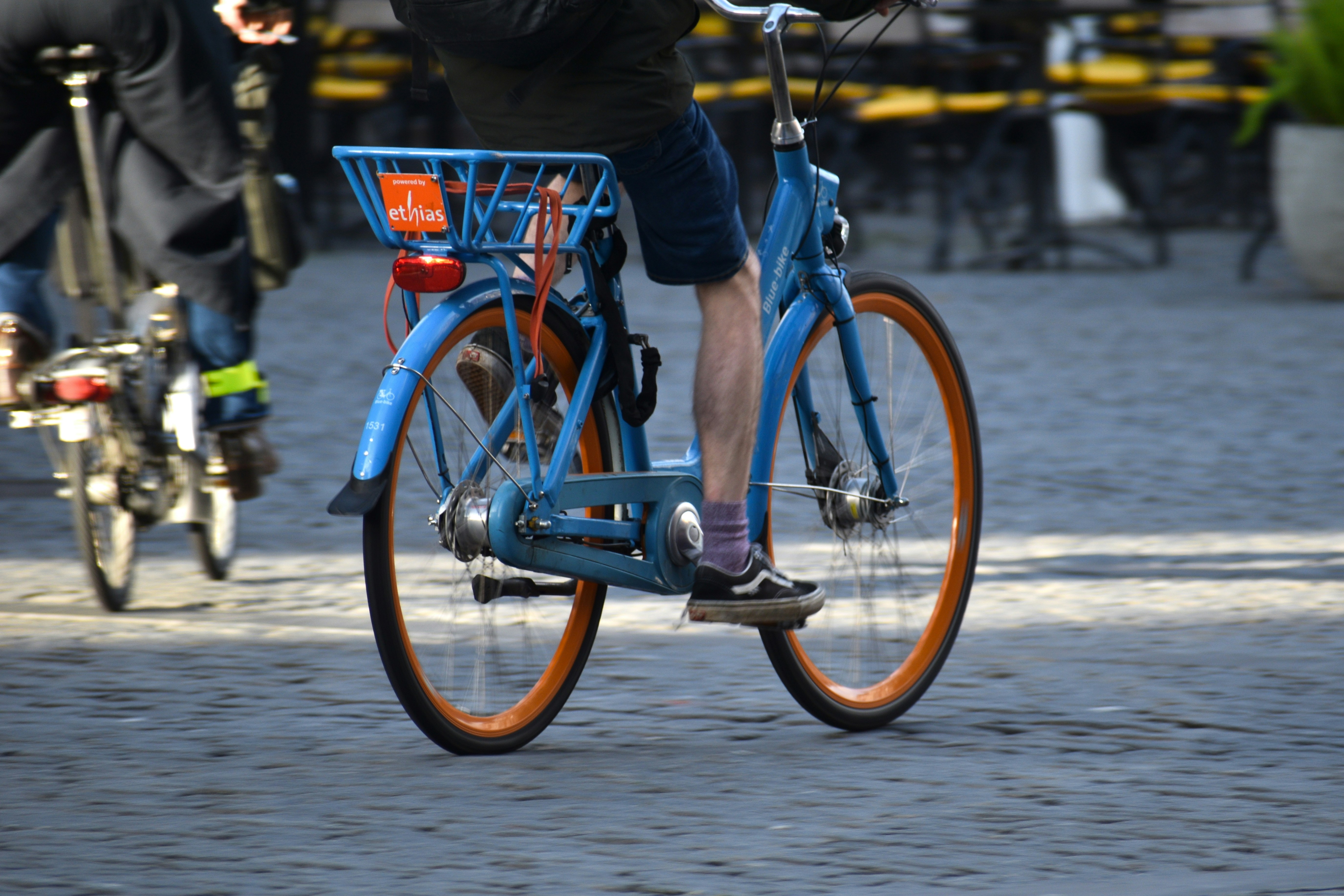 Someone is riding a blue bicycle down the street.