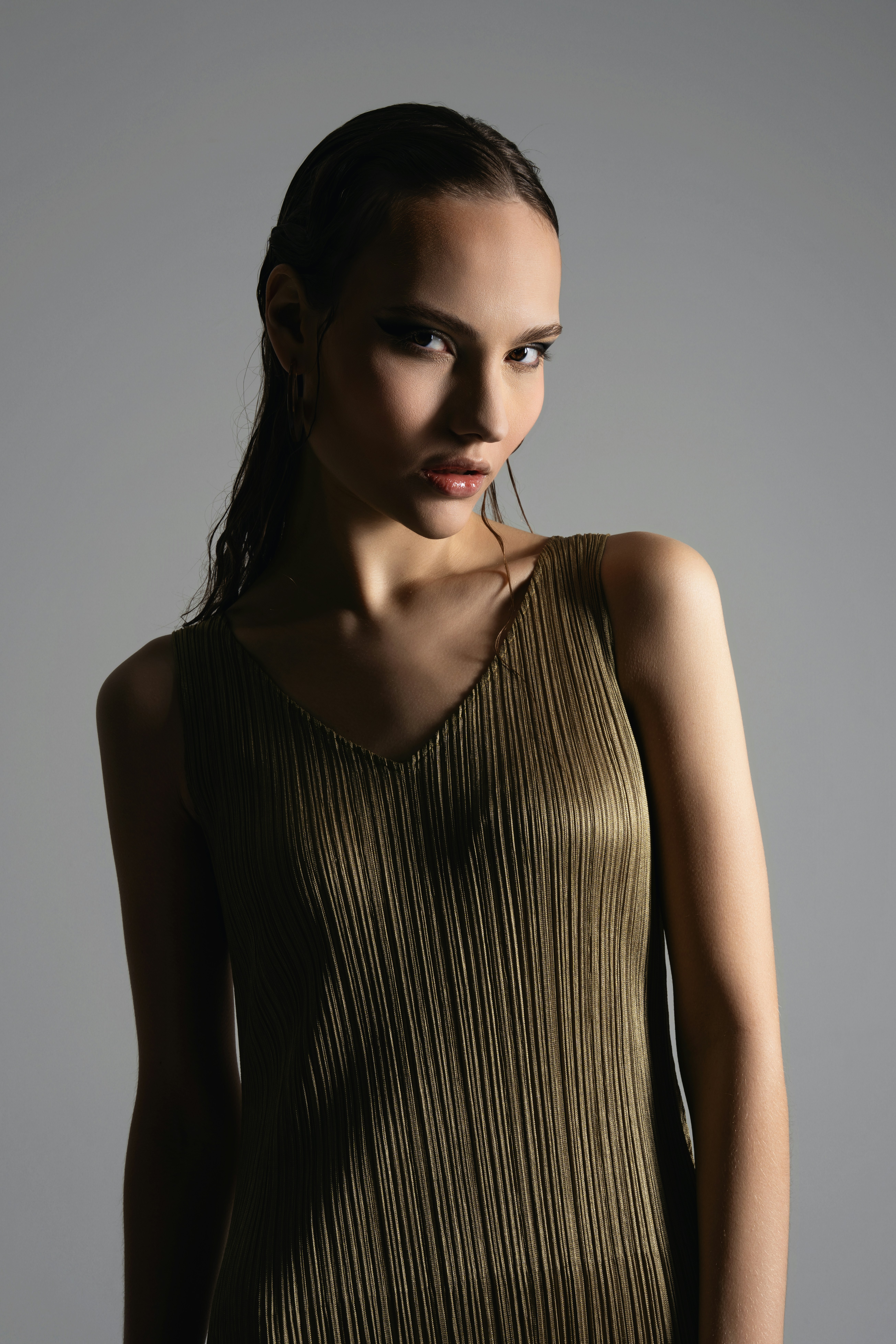 Elegant woman poses in a fashionable dress.