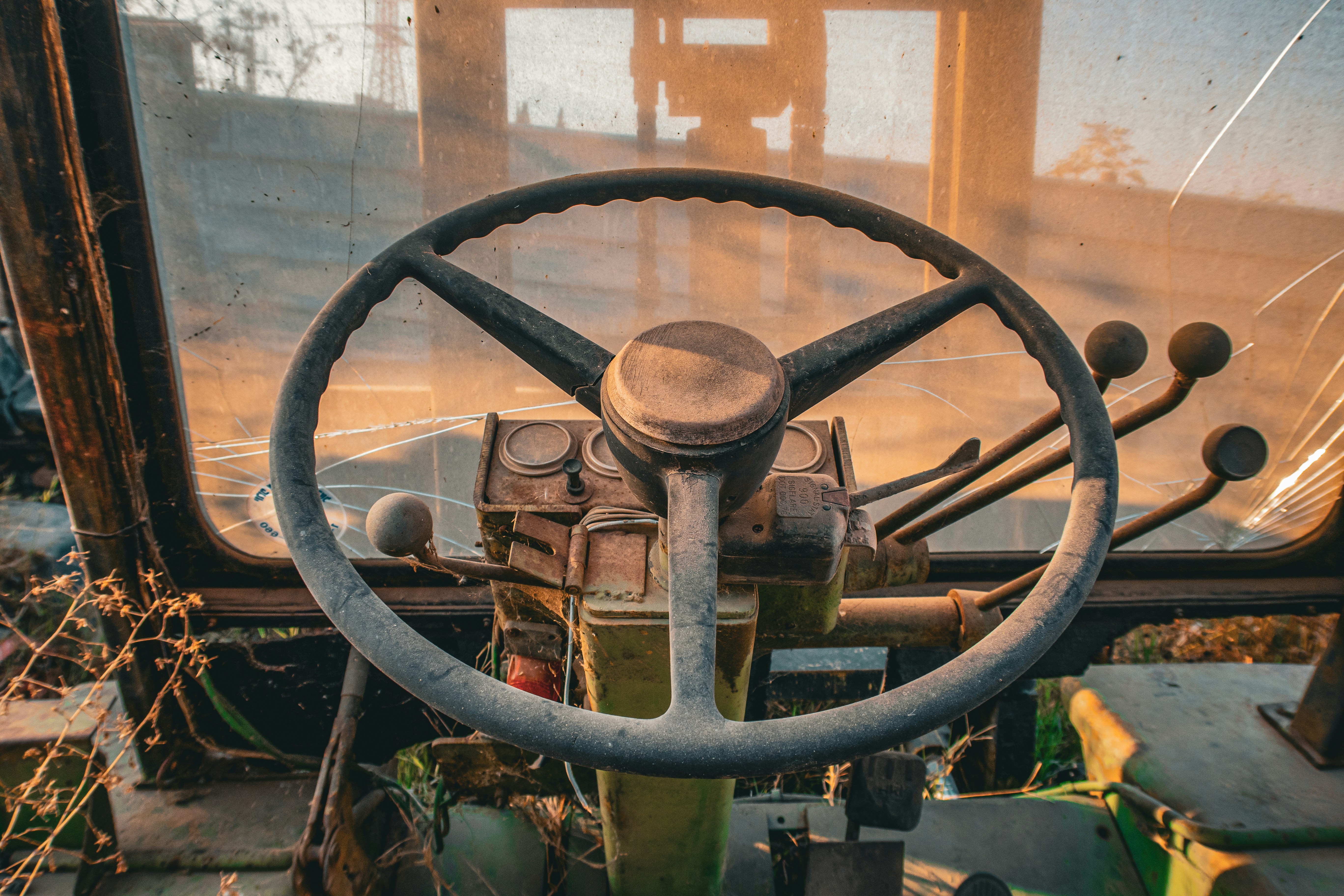 Here is a possible caption: steering wheel inside an old vehicle.