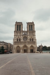 Notre dame cathedral stands tall on a cloudy day.