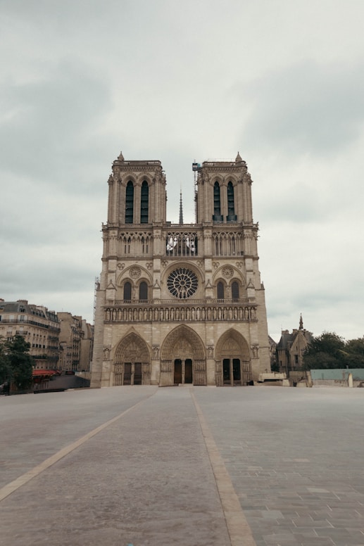 Notre dame cathedral stands tall on a cloudy day.