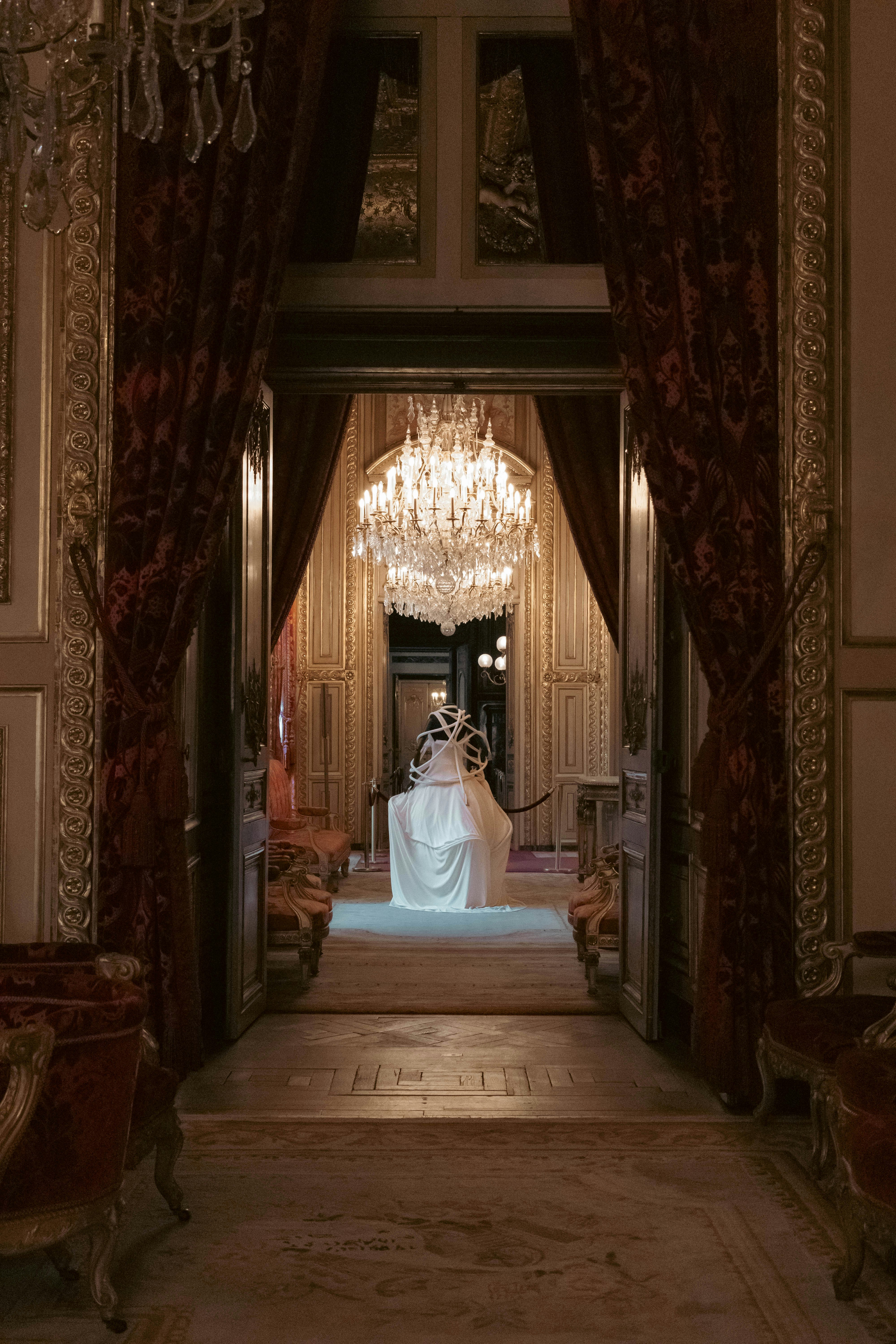 A grand hallway is adorned with chandeliers