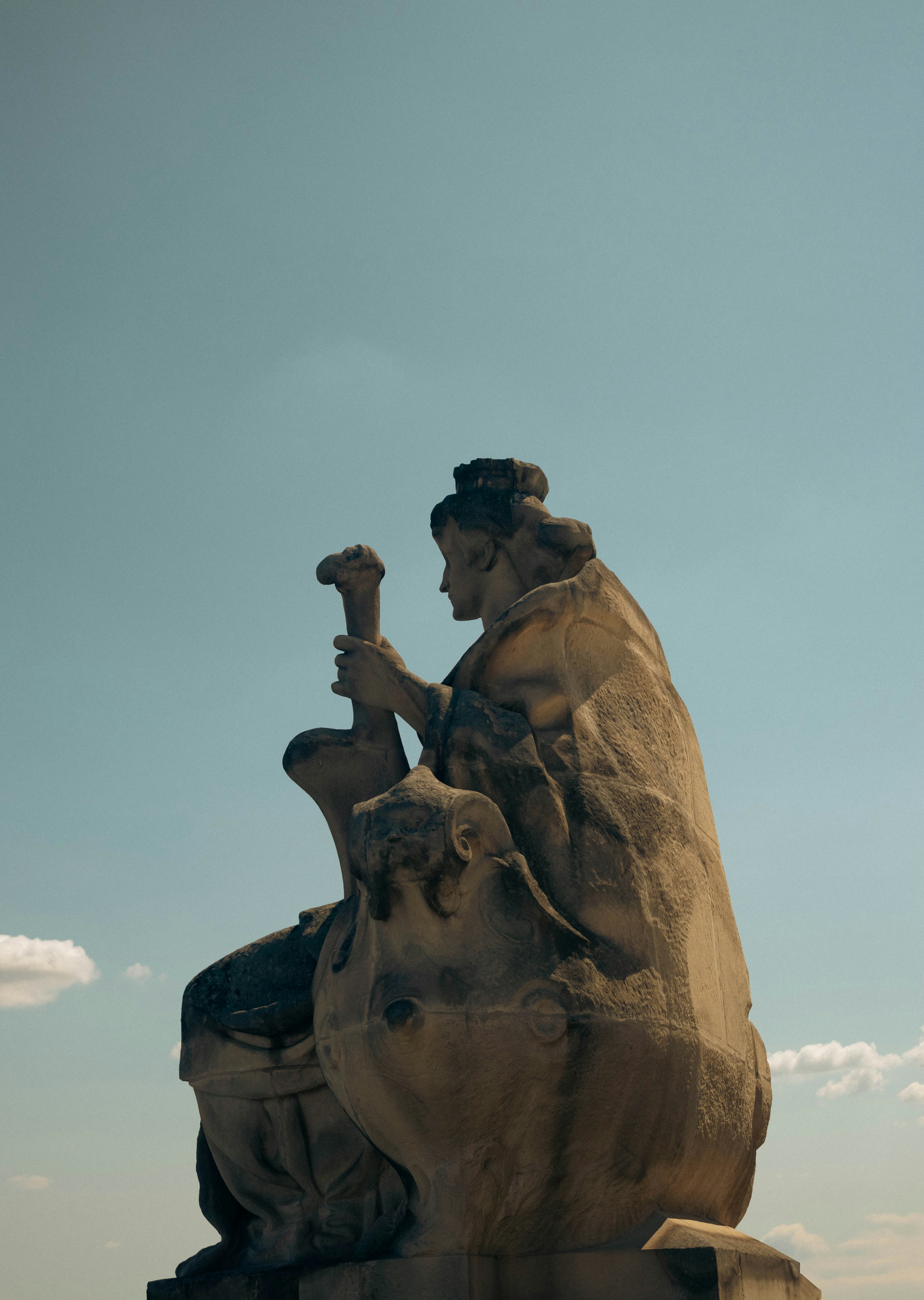 A statue sits against a clear, blue sky.