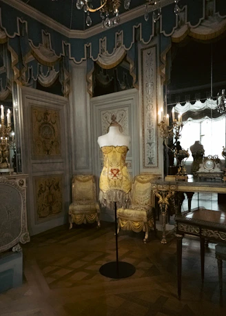 A dress form stands in an ornate, antique room.