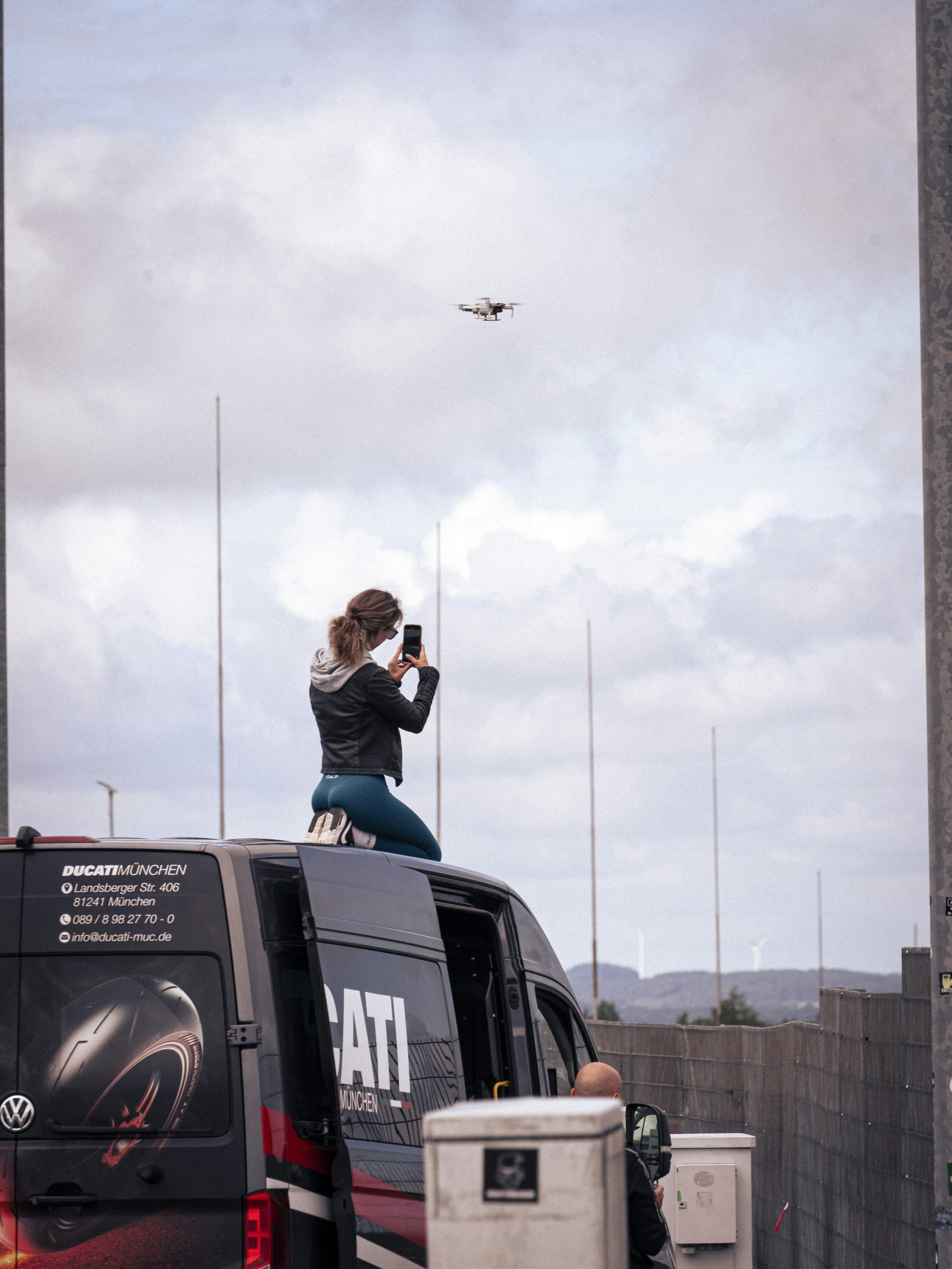 Une femme photographie un avion depuis le toit d’une camionnette.