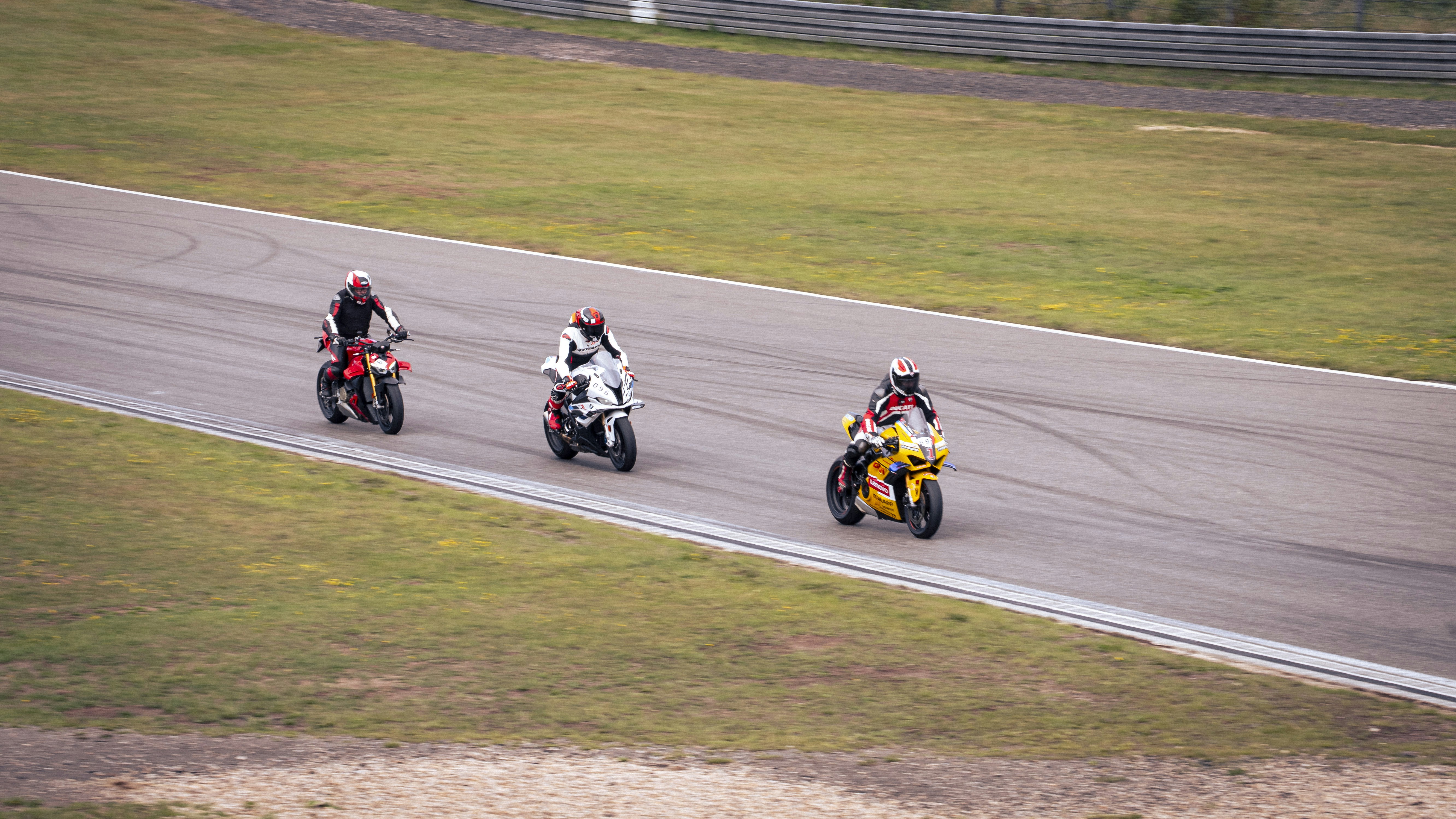 Sportbikes cornering on a racetrack during a track day.