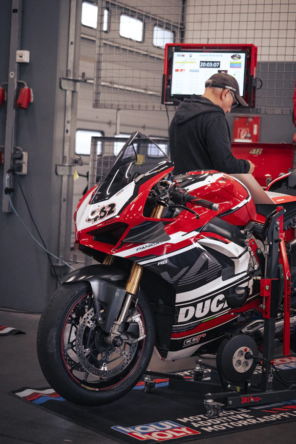 A motorcycle is being tested in a mechanic's shop.