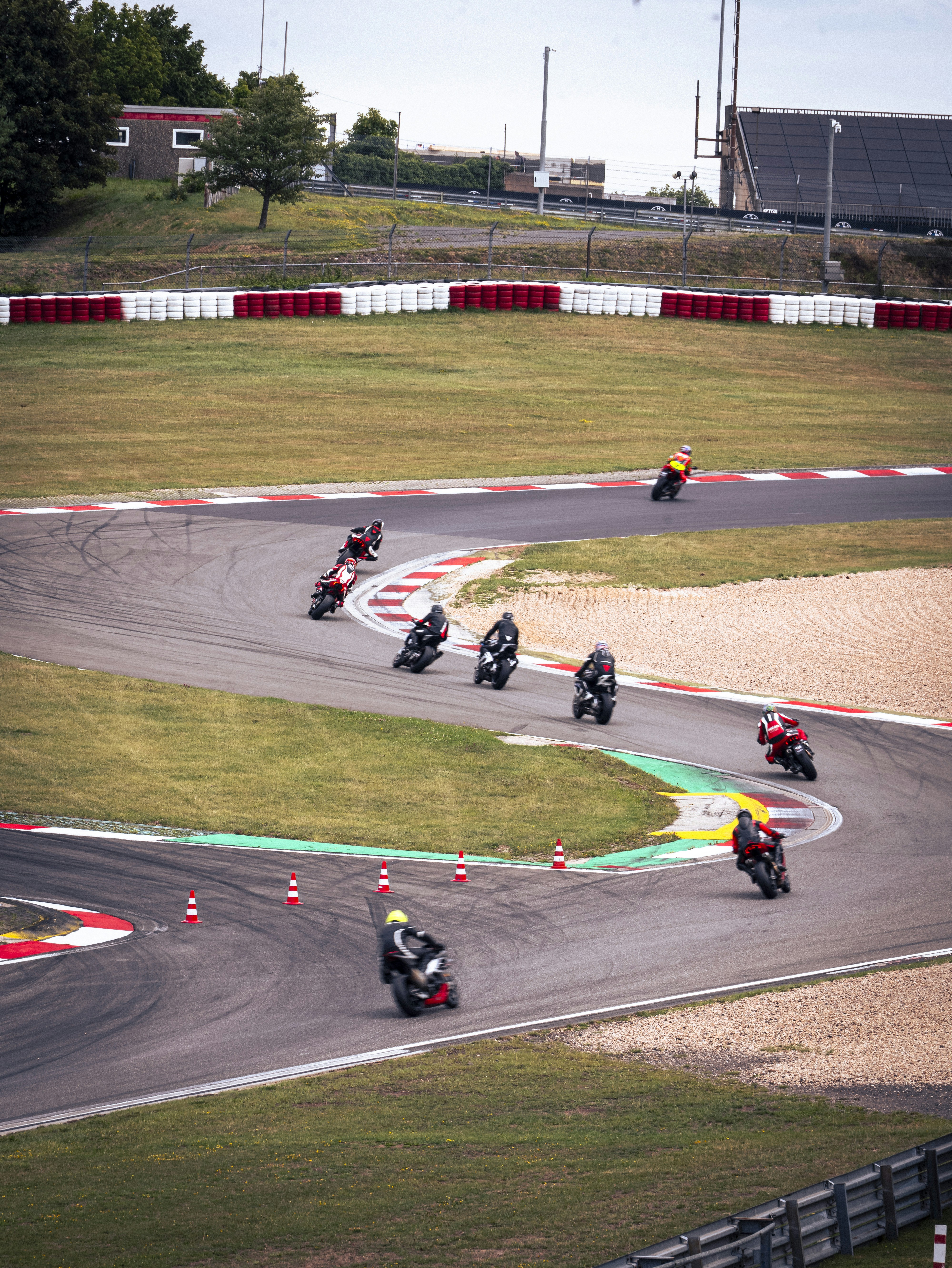 Motorcycles speed around a track, taking a sharp curve. photo – Free ...