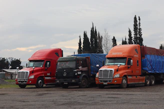 Three trucks are parked in a lot