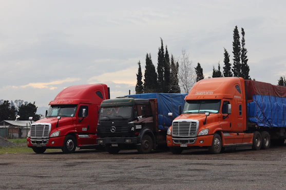 Three trucks are parked in a lot