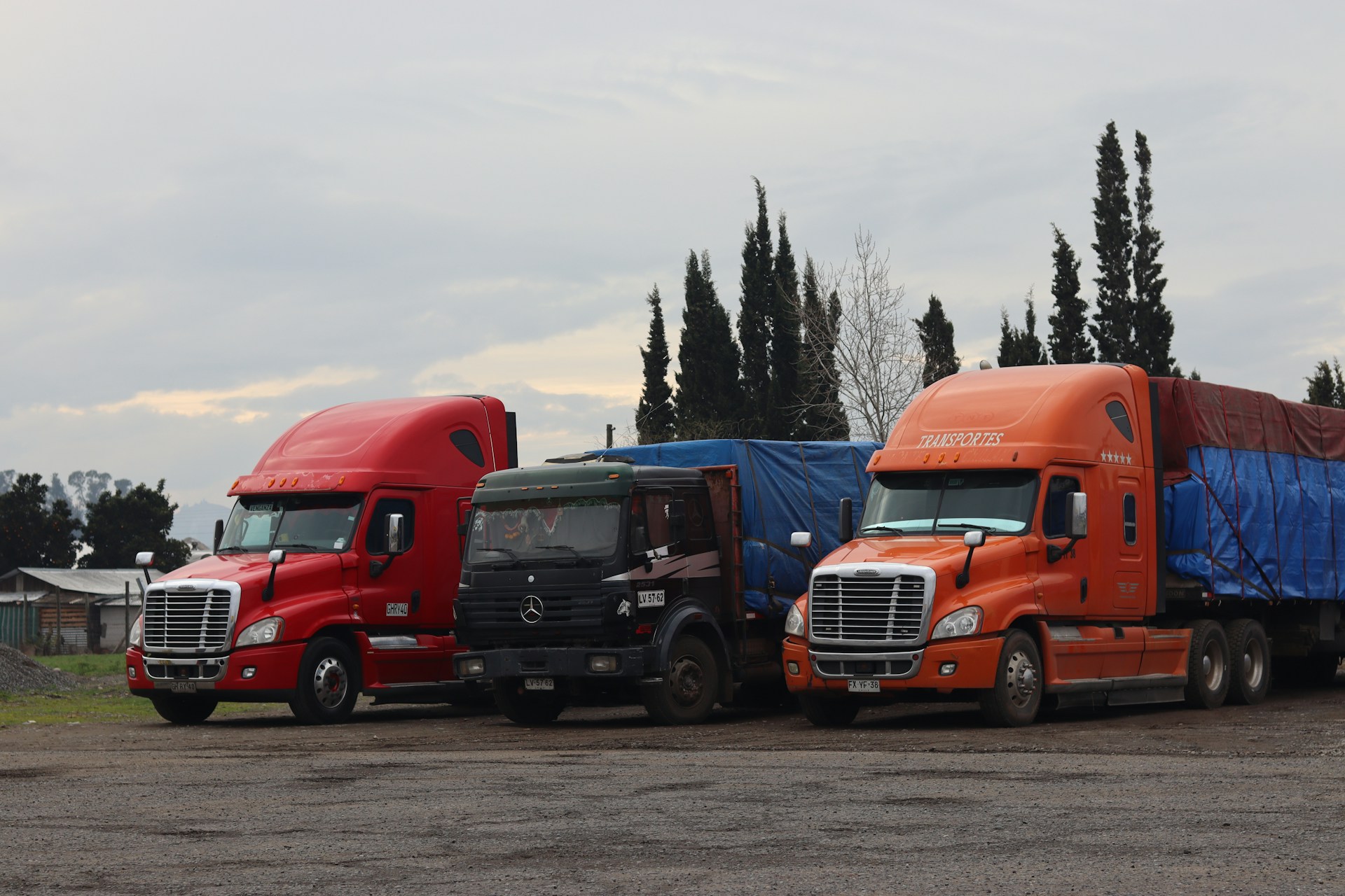 Three trucks are parked in a lot.