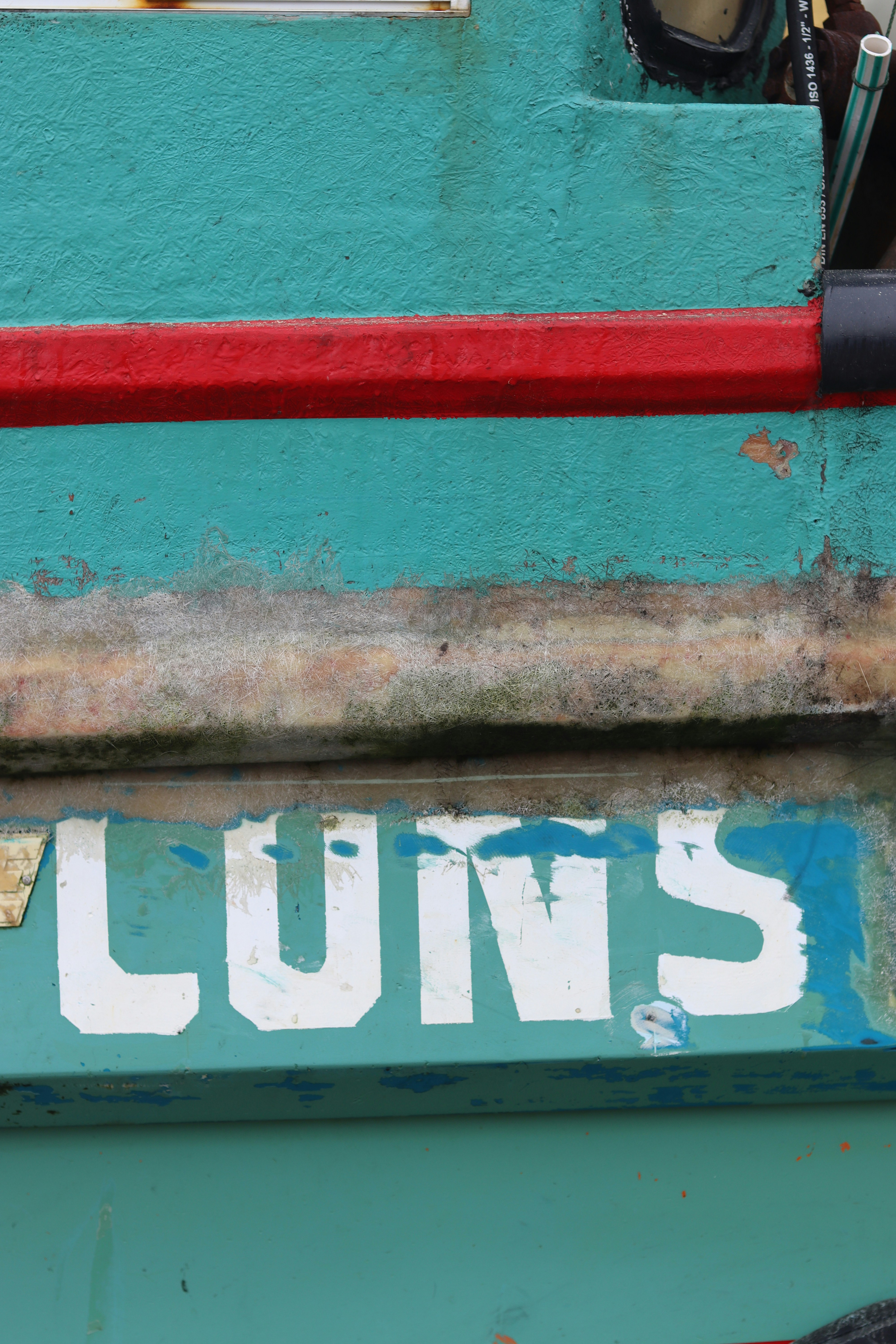 The word "luns" is painted on a teal surface.