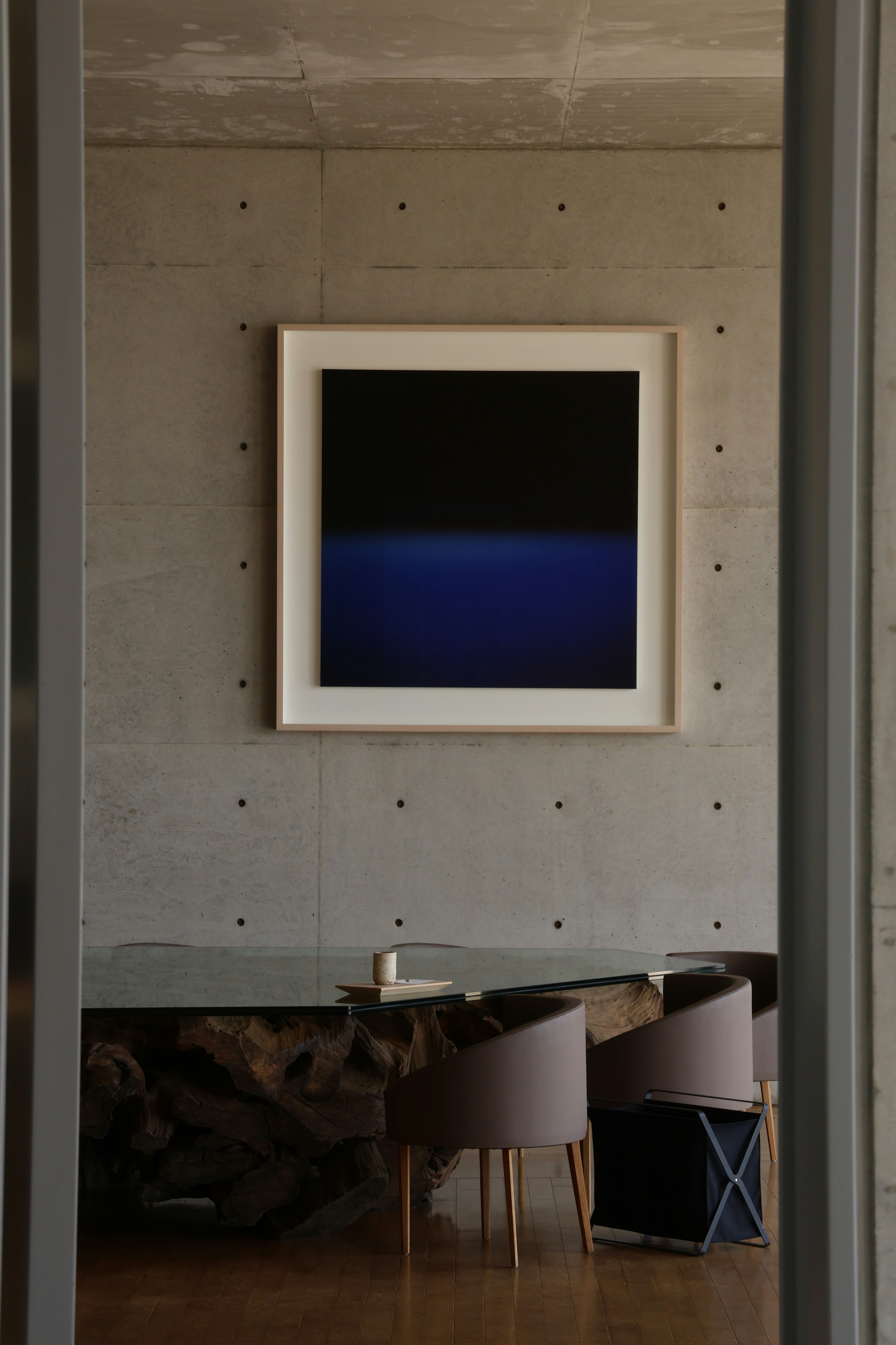 Modern art hangs above a minimalist table.