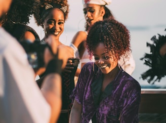 Women smile joyfully during a photo shoot.