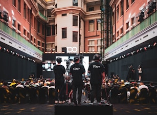 Staff watches over an event with a large audience.