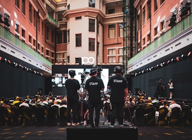 Staff watches over an event with a large audience.