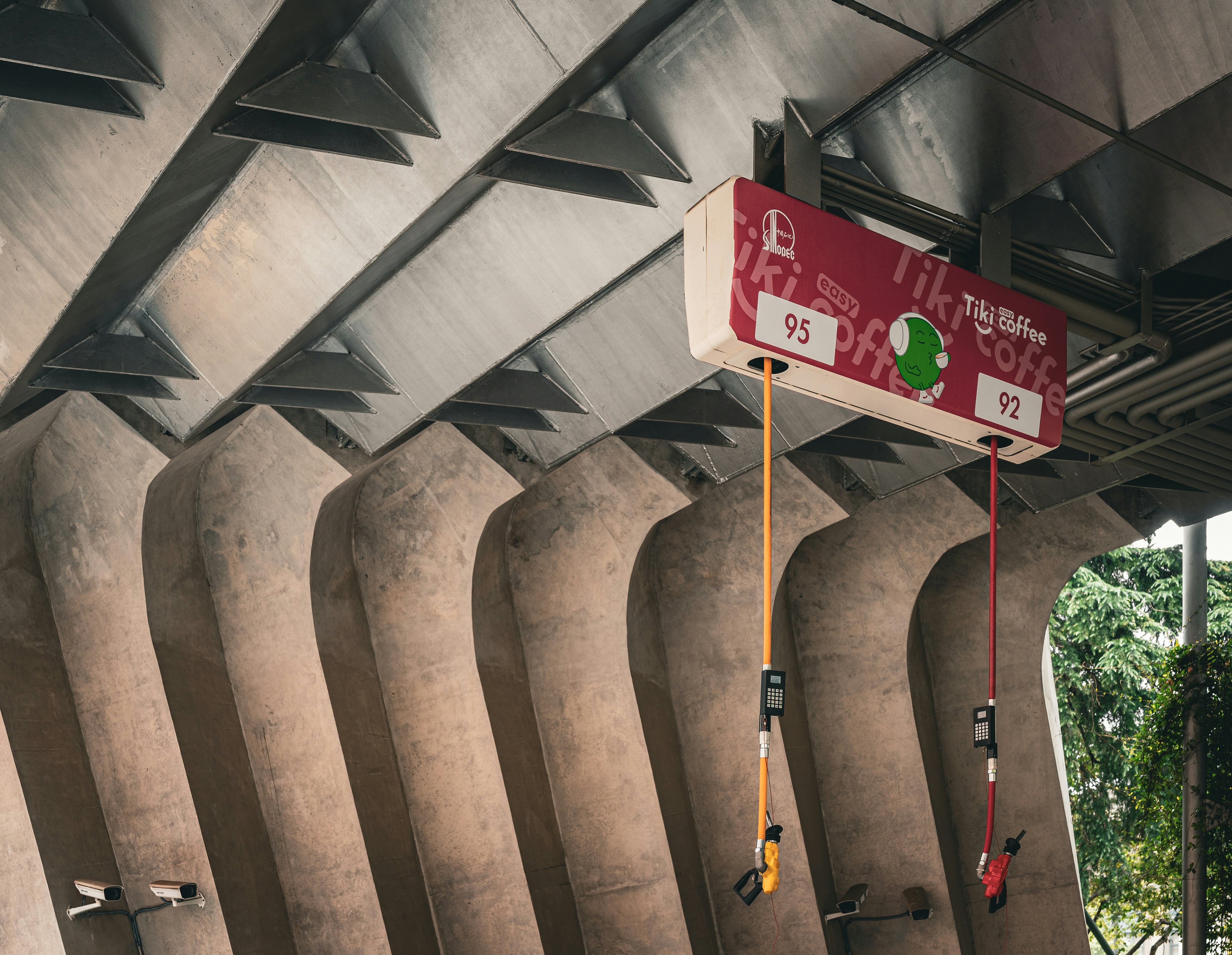 Una scatola rossa con delle corde è appesa sotto un ponte.