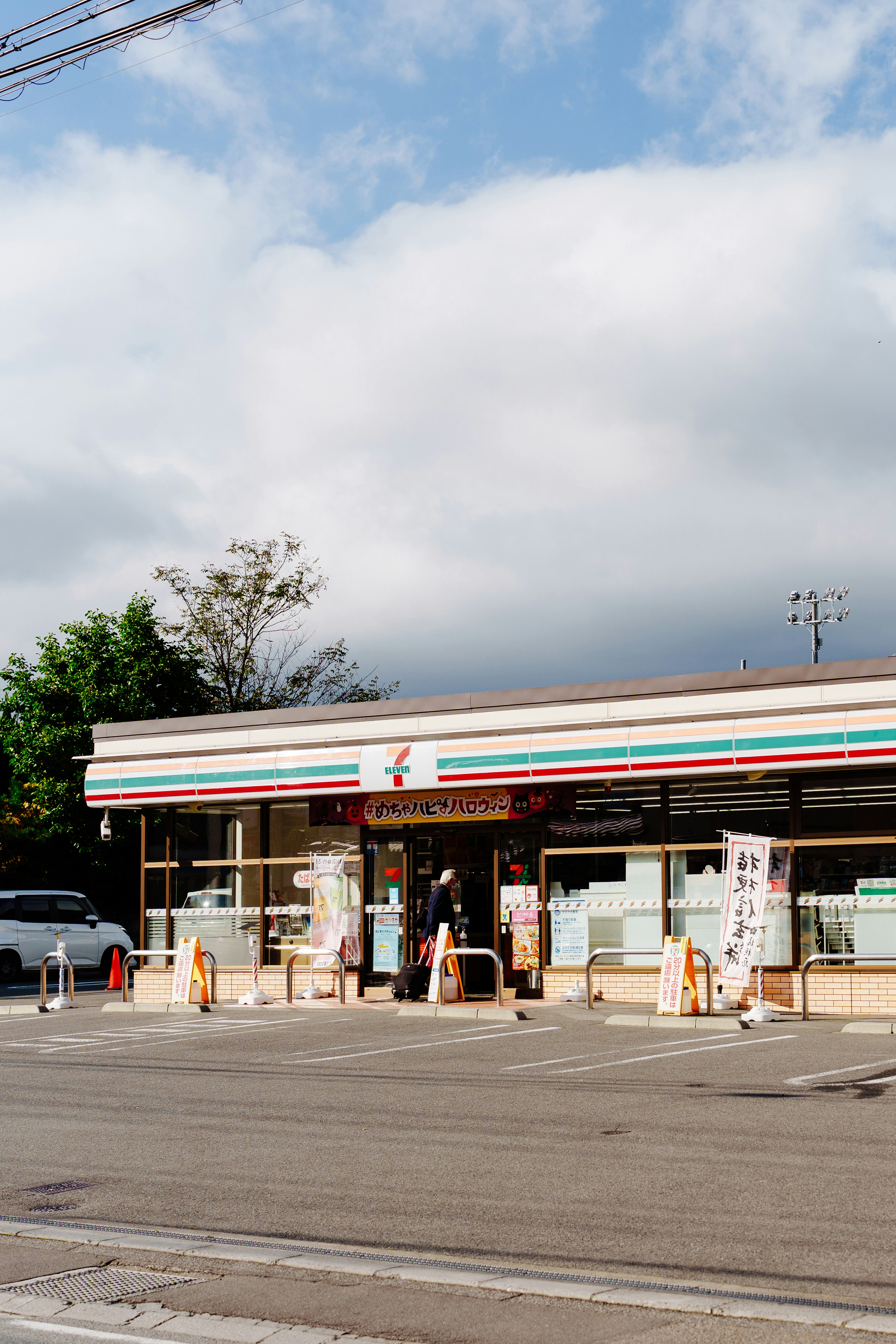 A 7-eleven store stands under a cloudy sky.