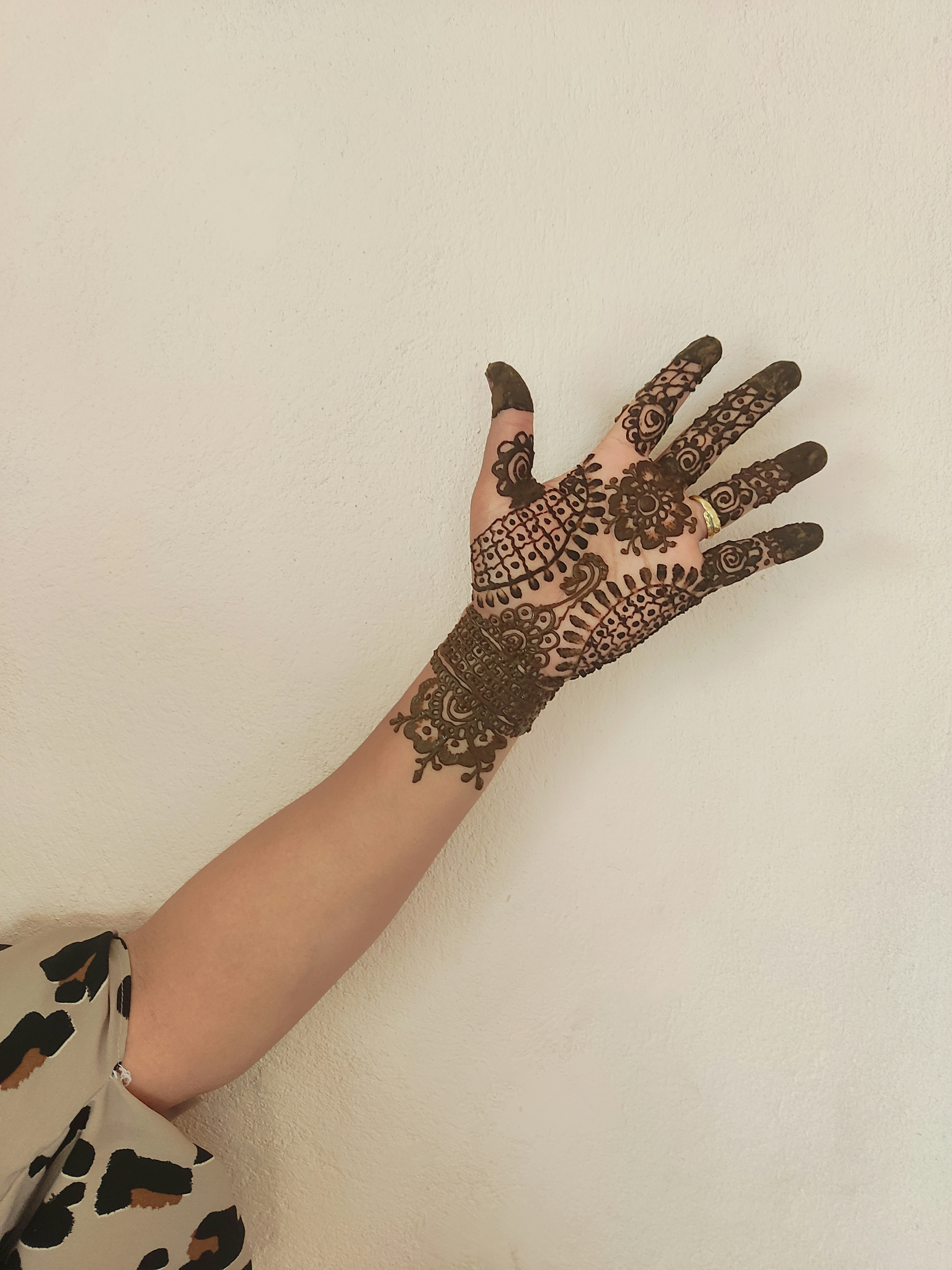Hand with intricate henna designs on it.