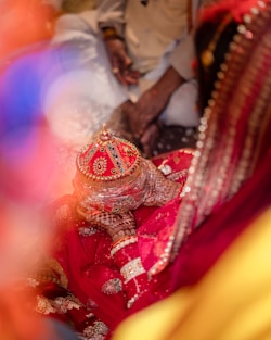 A bride holds a decorated vessel at her wedding.