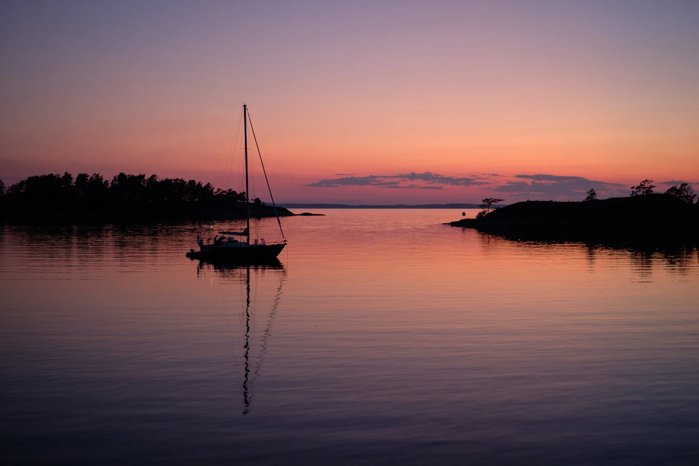 A sailboat on calm water at sunset