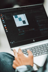 Person working on a laptop, coding and analyzing data.