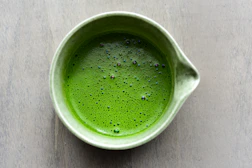 Matcha tea in a green ceramic bowl.