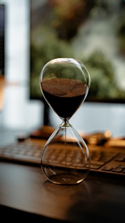 An hourglass counts down time on a desk.