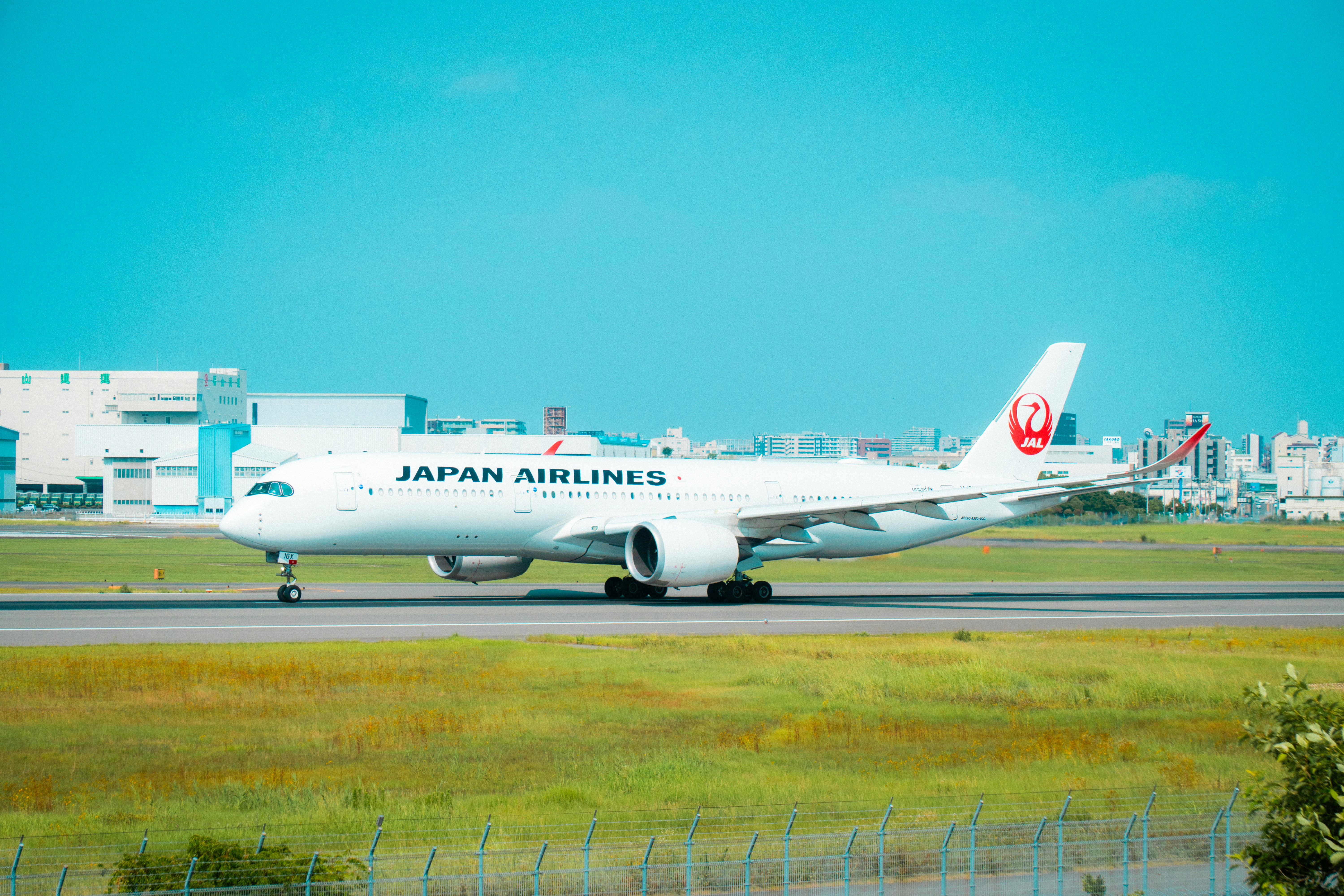 A japan airlines plane is on the runway.