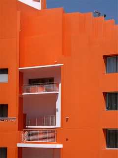 Bright orange building with white balconies and windows.
