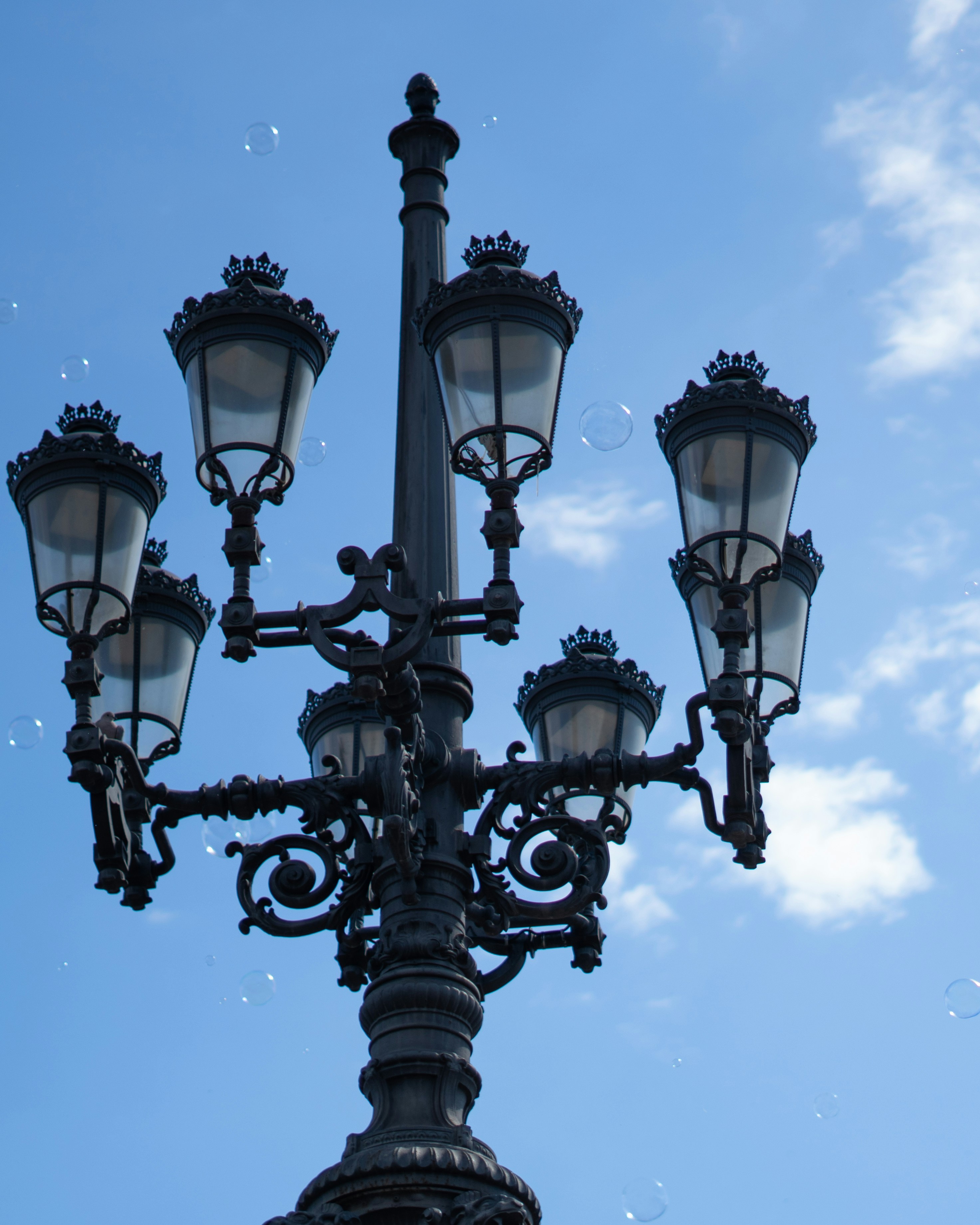 A detailed lamppost against a blue sky.