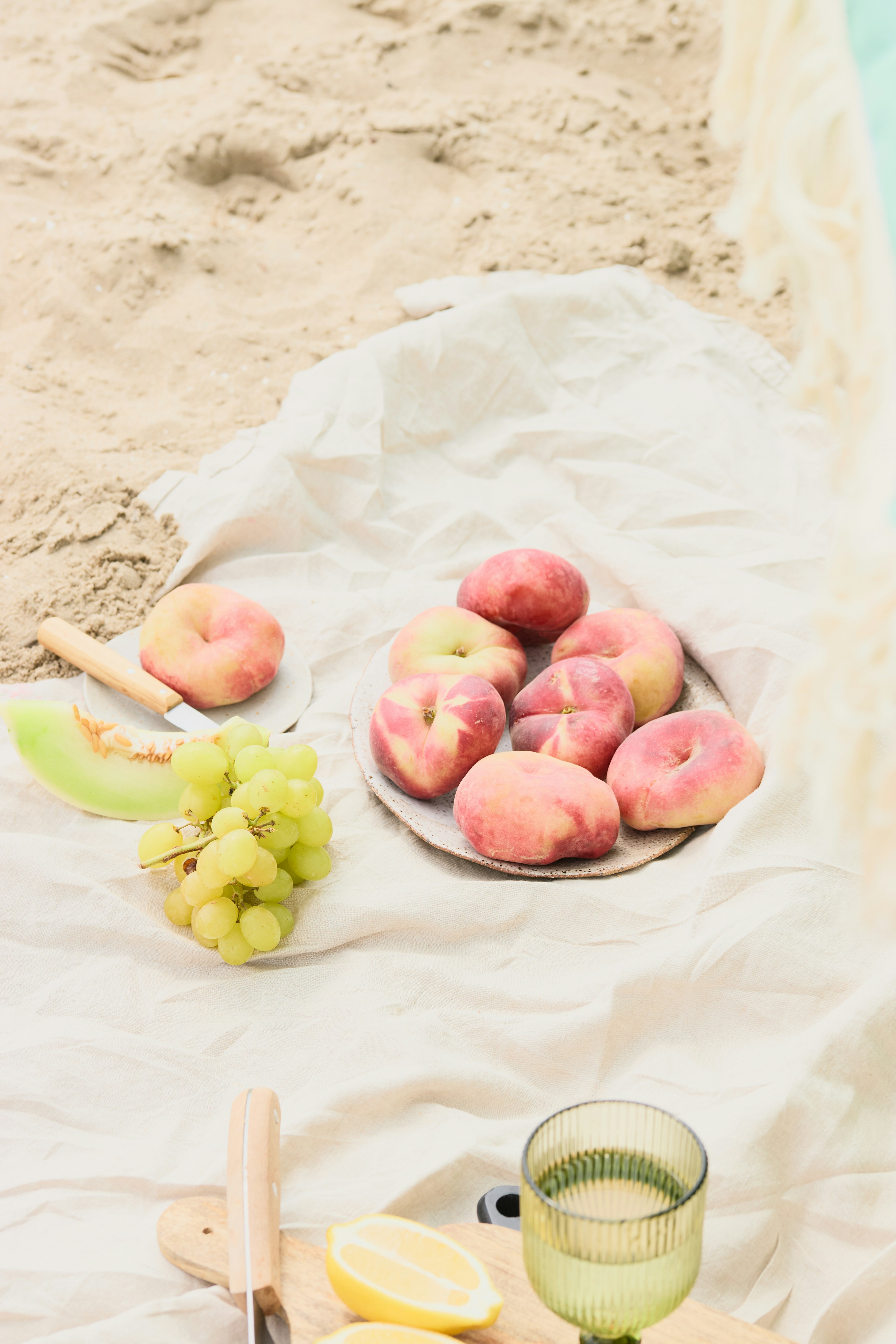 Fresh fruits are arranged on a beach picnic.