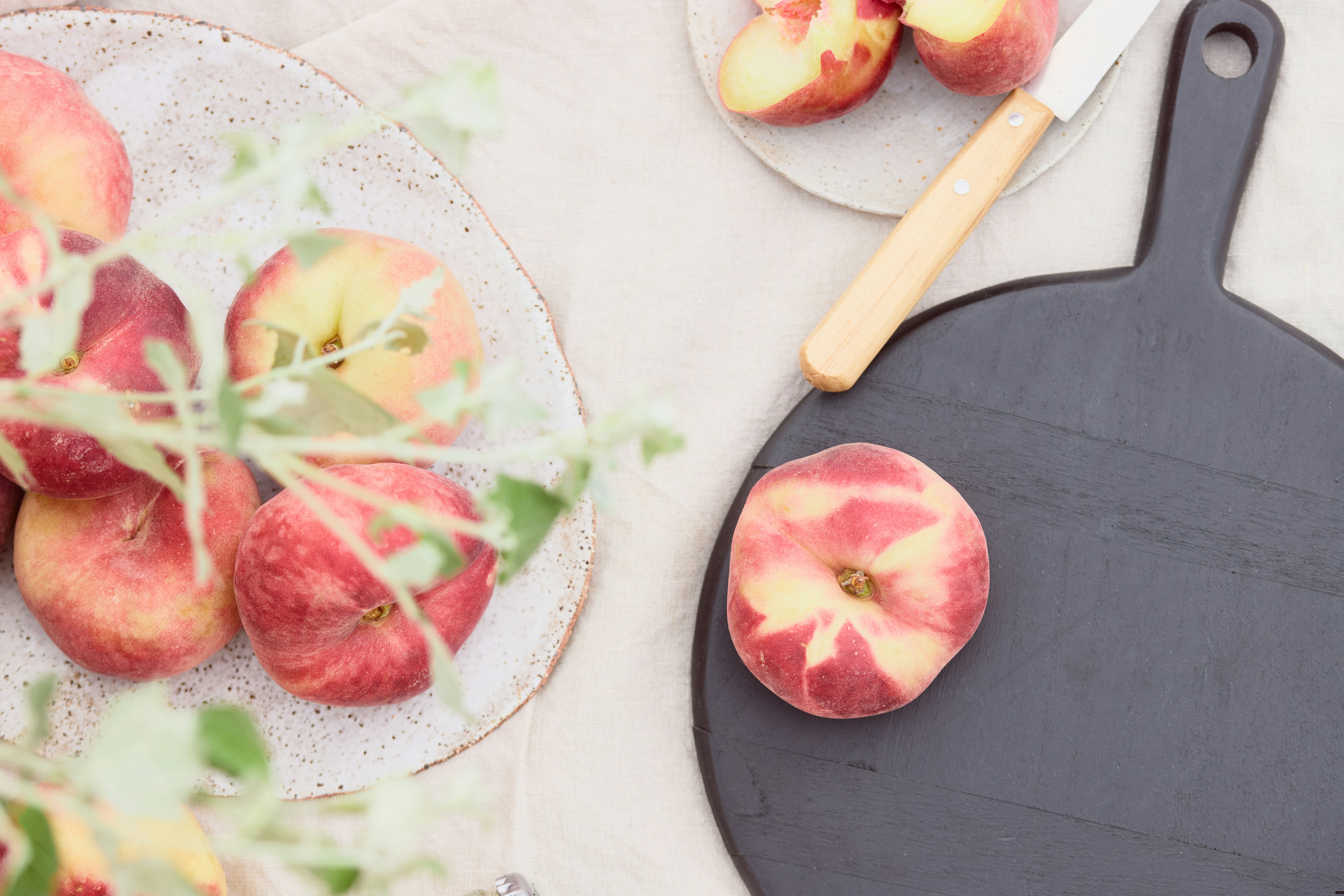 Peaches, a cutting board, and a knife.