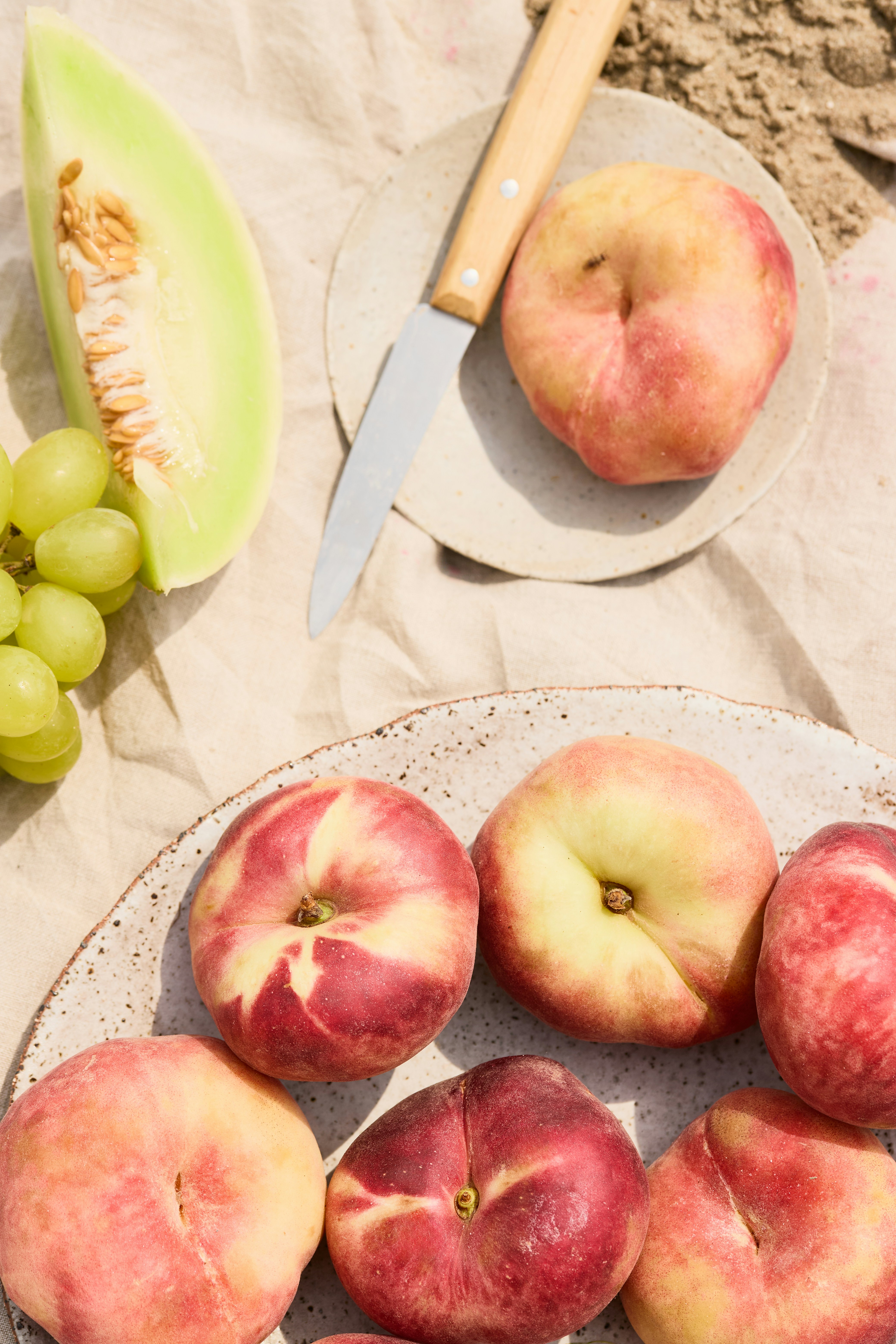 Fresh fruit is arranged on a neutral colored surface.